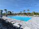 Large community pool surrounded by lounge chairs and palm trees, creating a resort-like atmosphere at 15968 Honeysuckle St, Port Charlotte, FL 33953