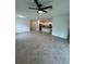 Spacious living room with an open layout featuring neutral tile flooring and ceiling fan at 15968 Honeysuckle St, Port Charlotte, FL 33953