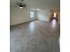 Open living room with tiled floor, ceiling fan and bright windows offering space to relax and enjoy at 15968 Honeysuckle St, Port Charlotte, FL 33953