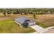 Aerial view showcases the property with lush green lawn, extended driveway, and convenient three-car garage at 16489 Trading Post Rd, Punta Gorda, FL 33955
