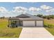 Charming single-story home with a spacious driveway and well-manicured lawn, featuring a three-car garage at 16489 Trading Post Rd, Punta Gorda, FL 33955