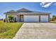 Charming single-story home with a spacious driveway and well-manicured lawn, featuring a three-car garage at 16489 Trading Post Rd, Punta Gorda, FL 33955