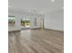 Bright, open living room featuring wood floors and large windows with sliding glass doors to outdoor pool area at 16489 Trading Post Rd, Punta Gorda, FL 33955