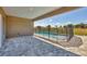 Covered patio leading to a pool area with a safety fence and a grassy area at 16489 Trading Post Rd, Punta Gorda, FL 33955