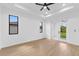 Bedroom with ceiling fan, windows to exterior view, neutral wall paint, trim and baseboards, and wood flooring at 1826 Narrington Ave, North Port, FL 34288