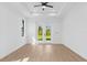 Large bedroom with ceiling fan, natural light, neutral wall paint, trim and baseboards, and wood flooring at 1826 Narrington Ave, North Port, FL 34288