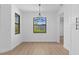 Dining area with modern chandelier, large window, neutral paint, trim and baseboards, and wood flooring at 1826 Narrington Ave, North Port, FL 34288