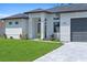 Close up of a light grey house with a gray driveway and landscaping at 1826 Narrington Ave, North Port, FL 34288