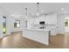 Bright kitchen features stainless appliances, white cabinets, and an island with hanging lights at 1826 Narrington Ave, North Port, FL 34288