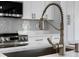 Modern kitchen faucet with stainless steel appliances and sleek white cabinets at 1826 Narrington Ave, North Port, FL 34288