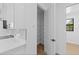 Pantry and kitchen featuring white cabinets, quartz countertops, stainless appliances, and modern fixtures at 1826 Narrington Ave, North Port, FL 34288