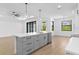 Kitchen island with gray cabinetry, stainless steel appliances, quartz countertops, and an open floor plan at 1826 Narrington Ave, North Port, FL 34288