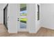 Open floorplan with glass doors to backyard, neutral wall paint, light trim and baseboards, and wood flooring at 1826 Narrington Ave, North Port, FL 34288