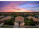Beautiful aerial view of homes with tile roofs along a lake as the sun sets and the sky turns shades of pink and purple at 20171 Tesoro Dr, Venice, FL 34293
