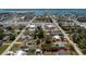 Aerial view showcases a single-story home on a tree-filled lot, close to the ocean and roads, outlined in red at 2033 Georgia Ave, Englewood, FL 34224