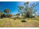 Backyard features a beautiful tree, privacy fence, and lush landscaping at 2033 Georgia Ave, Englewood, FL 34224