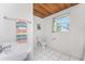 Practical bathroom with clean white fixtures, tile floor, and natural light from the window at 2033 Georgia Ave, Englewood, FL 34224