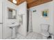 Well-lit bathroom featuring a pedestal sink, shower, and toilet at 2033 Georgia Ave, Englewood, FL 34224