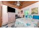 Cozy bedroom featuring a wooden ceiling, plush bed with marine themed bedding, and a large television at 2033 Georgia Ave, Englewood, FL 34224