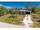 This home boasts a lush front yard, mature palm tree, and convenient carport at 2033 Georgia Ave, Englewood, FL 34224