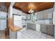 Well-lit kitchen with gray cabinets, white appliances, and bright, clean white tile flooring at 2033 Georgia Ave, Englewood, FL 34224