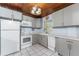 Well-lit kitchen with white appliances, gray cabinets, and a window at 2033 Georgia Ave, Englewood, FL 34224