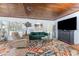 Bright living room featuring wood ceiling, colorful rug, comfortable seating, and a large television at 2033 Georgia Ave, Englewood, FL 34224