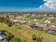 An aerial perspective capturing the entire property, showcasing the landscaping, pool, and surrounding neighborhood with clear blue skies at 212 Rotonda E Blvd, Rotonda West, FL 33947