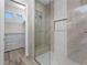 Bright bathroom featuring a glass shower and view of a walk-in closet with custom shelving at 212 Rotonda E Blvd, Rotonda West, FL 33947