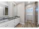 Bathroom with double sink vanity and walk-in closet with custom shelving at 212 Rotonda E Blvd, Rotonda West, FL 33947