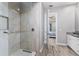 Modern glass shower with a view through to the main bedroom and double sink vanity at 212 Rotonda E Blvd, Rotonda West, FL 33947