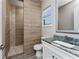 Well-lit bathroom with a granite countertop, wood-look tile, and a glass shower at 212 Rotonda E Blvd, Rotonda West, FL 33947