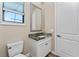 Bathroom featuring a white vanity, granite countertop, toilet and a decorative mirror at 212 Rotonda E Blvd, Rotonda West, FL 33947