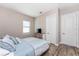 Well-lit bedroom with wood-look flooring, a woven dresser and a white door at 212 Rotonda E Blvd, Rotonda West, FL 33947