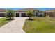 A charming single-story home featuring a three-car garage and a beautifully landscaped front yard with stone driveway at 212 Rotonda E Blvd, Rotonda West, FL 33947