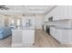 Open-concept kitchen with white cabinets, modern appliances, and an island seamlessly flowing into the living area at 212 Rotonda E Blvd, Rotonda West, FL 33947