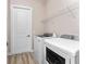 Functional laundry room featuring a white washer and dryer and a wire rack for storage at 212 Rotonda E Blvd, Rotonda West, FL 33947