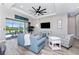 Spacious living room with modern fan, comfortable seating, and a sliding glass door leading to the outdoor pool area at 212 Rotonda E Blvd, Rotonda West, FL 33947