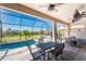 Screened-in patio with dining and lounge area overlooking pool and lawn at 212 Rotonda E Blvd, Rotonda West, FL 33947