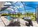 Screened-in lanai with covered pool, lounge area, and beautiful green backyard at 212 Rotonda E Blvd, Rotonda West, FL 33947