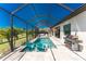 Luxury outdoor living with covered pool, patio, grill, and stylish seating at 212 Rotonda E Blvd, Rotonda West, FL 33947