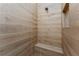 Modern shower featuring wood-look tile, a built-in seat and a niche for storage at 212 Rotonda E Blvd, Rotonda West, FL 33947