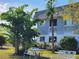 Relaxing outdoor seating area with lush trees and greenery surrounding the condo building at 22375 Edgewater Dr # F219, Port Charlotte, FL 33980