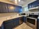 Updated kitchen with blue cabinets, stainless steel appliances, and a well-lit sink area at 22375 Edgewater Dr # F219, Port Charlotte, FL 33980