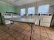 Community laundry room. There are several white washing machines and a table on a tiled floor at 22375 Edgewater Dr # F219, Port Charlotte, FL 33980
