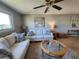 Comfortable living room with white sofas, wood flooring, and a glass coffee table; beach artwork included at 22375 Edgewater Dr # F219, Port Charlotte, FL 33980
