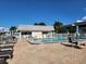 A refreshing community swimming pool is surrounded by a secure white fence and comfortable lounge furniture at 22375 Edgewater Dr # F219, Port Charlotte, FL 33980