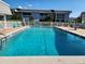 Refreshing pool area surrounded by a white picket fence, with condos in the background at 22375 Edgewater Dr # F219, Port Charlotte, FL 33980