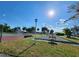 A shuffleboard court is adjacent to a tennis court. A lamppost lights the shuffleboard court at 22375 Edgewater Dr # F219, Port Charlotte, FL 33980