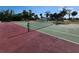Outdoor tennis court on a sunny day. The court is green and red with a green net at 22375 Edgewater Dr # F219, Port Charlotte, FL 33980